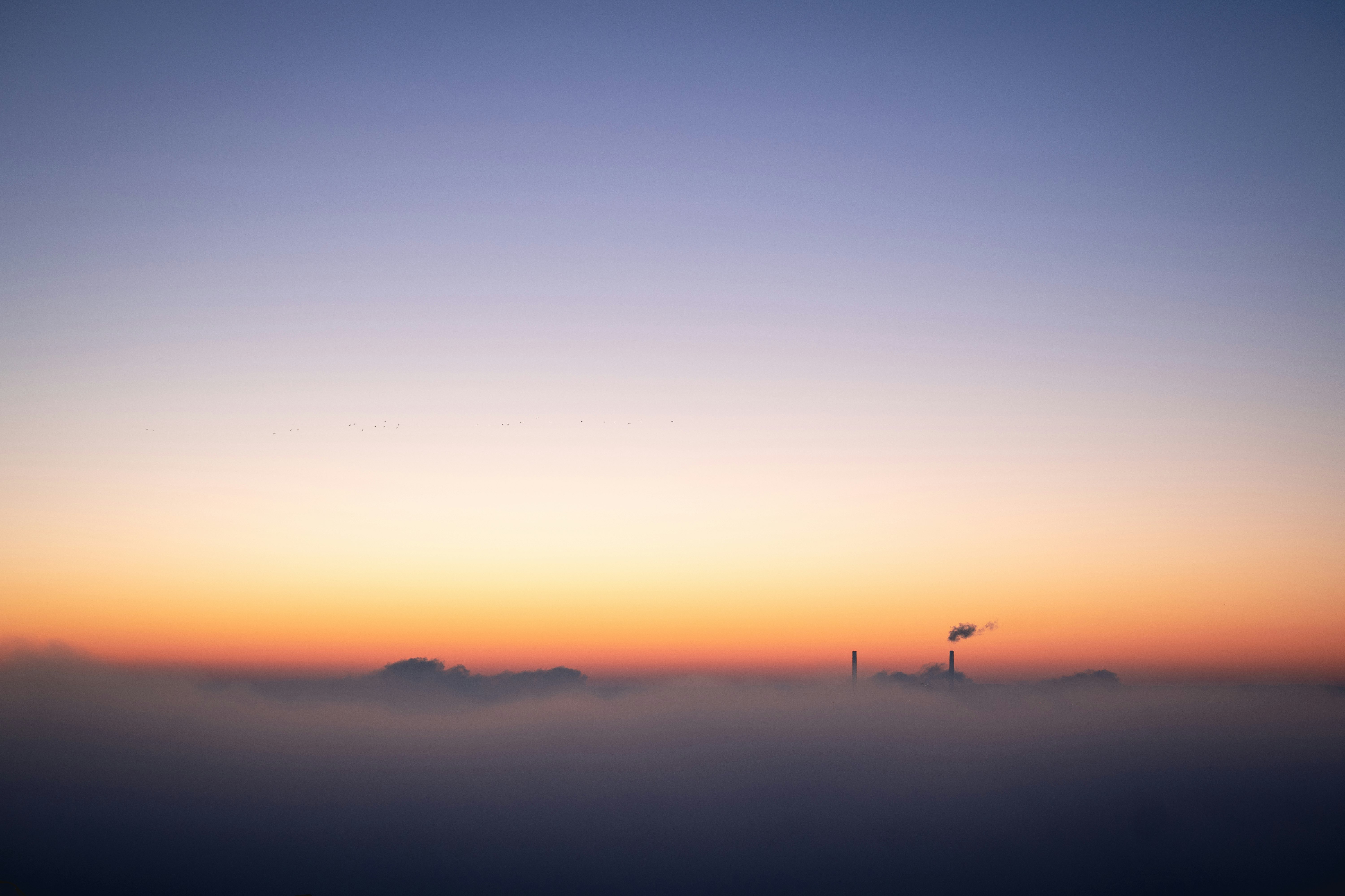 silhouette of person standing on hill during sunset